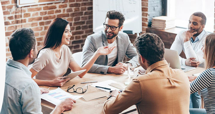 Workers sitting outside on a coffee break with electronic devices including laptop ipad and phone